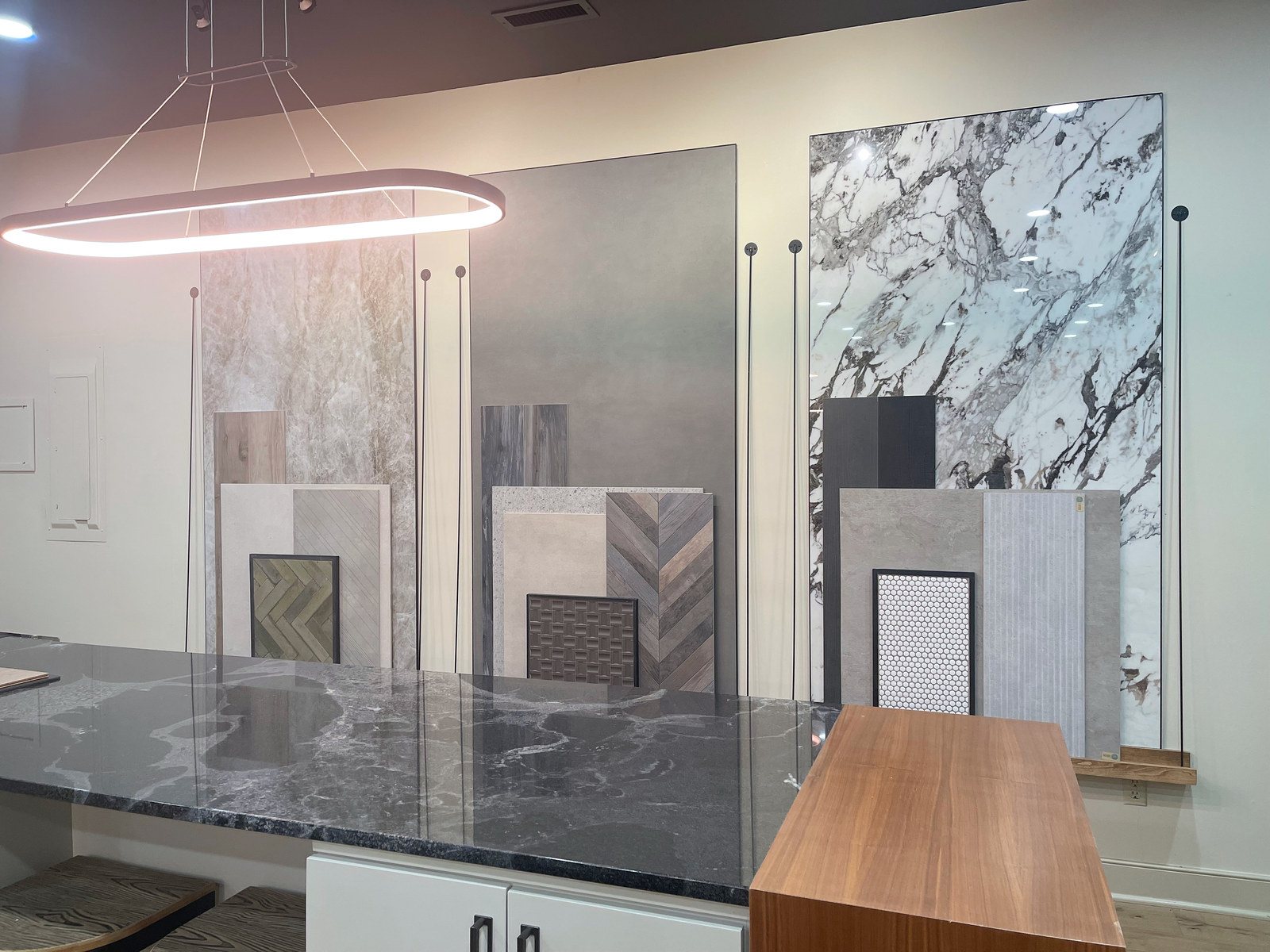 Stone slabs, tile samples and a dark veined countertop in the CIDC showroom