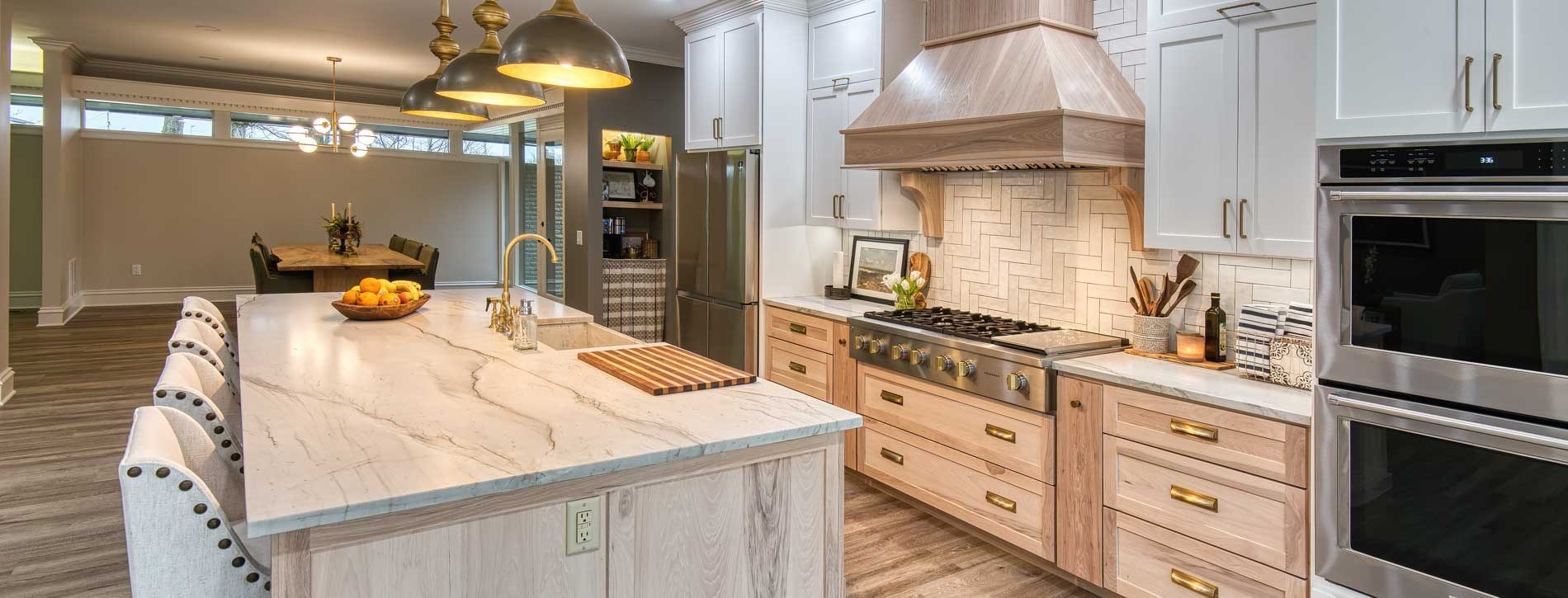 Design Builders kitchen with light cabinetry and a wood hood; cabinetry supplied by CIDC